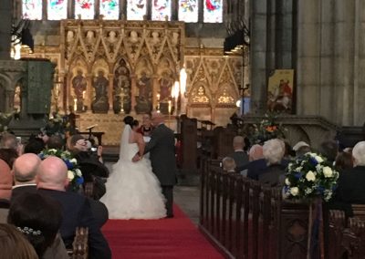 A wedding couple at front of the Minster stand before the Vicar as he conducts their wedding.